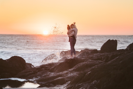 family law on the fraser coast - mother holding baby on the beach waving